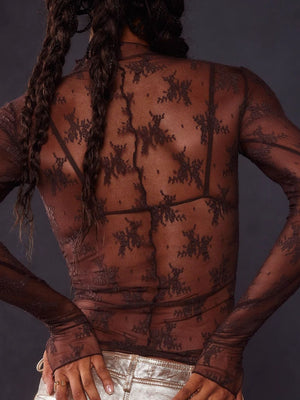 Dark brown floral lace illusion mock neck top with long sleeves, showing bra underneath.
