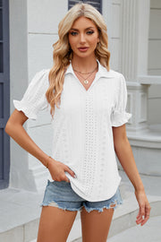 White eyelet polo blouse with short puff sleeves and ruffled cuffs.