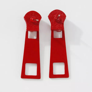 Red zipper drop earrings with square cutouts and alloy hardware.