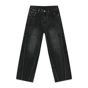 Dark wash denim trousers with exaggerated seam details and a wide leg.