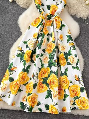 Yellow floral midi dress with a pleated skirt and a bow detail.