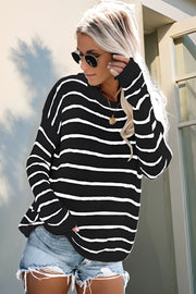 Relaxed black and white stripe knit pullover sweater with crew neck and long sleeves.