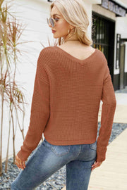 Brown waffle knit sweater with V-neck and long sleeves, styled with jeans.