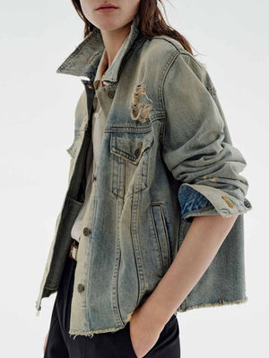 Distressed blue denim trucker jacket with button-up front and frayed hem.