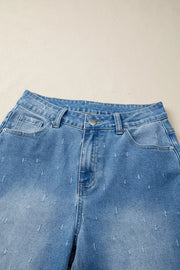 High-rise light wash denim jeans with distressed details and a raw hem.