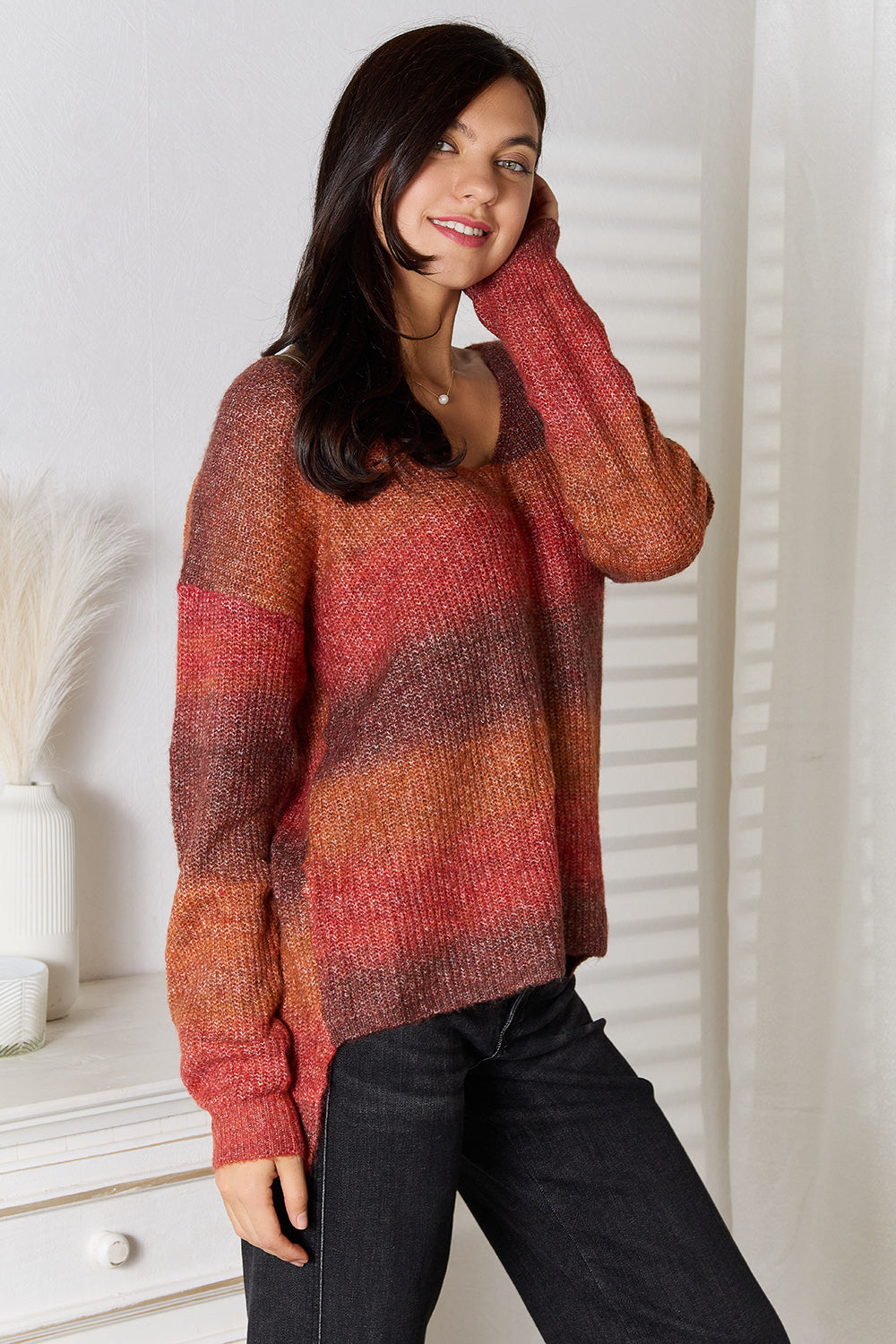 Sunset Stripe Slouchy V-Neck Knit sweater in brick red with ombre stripes and ribbed cuffs.