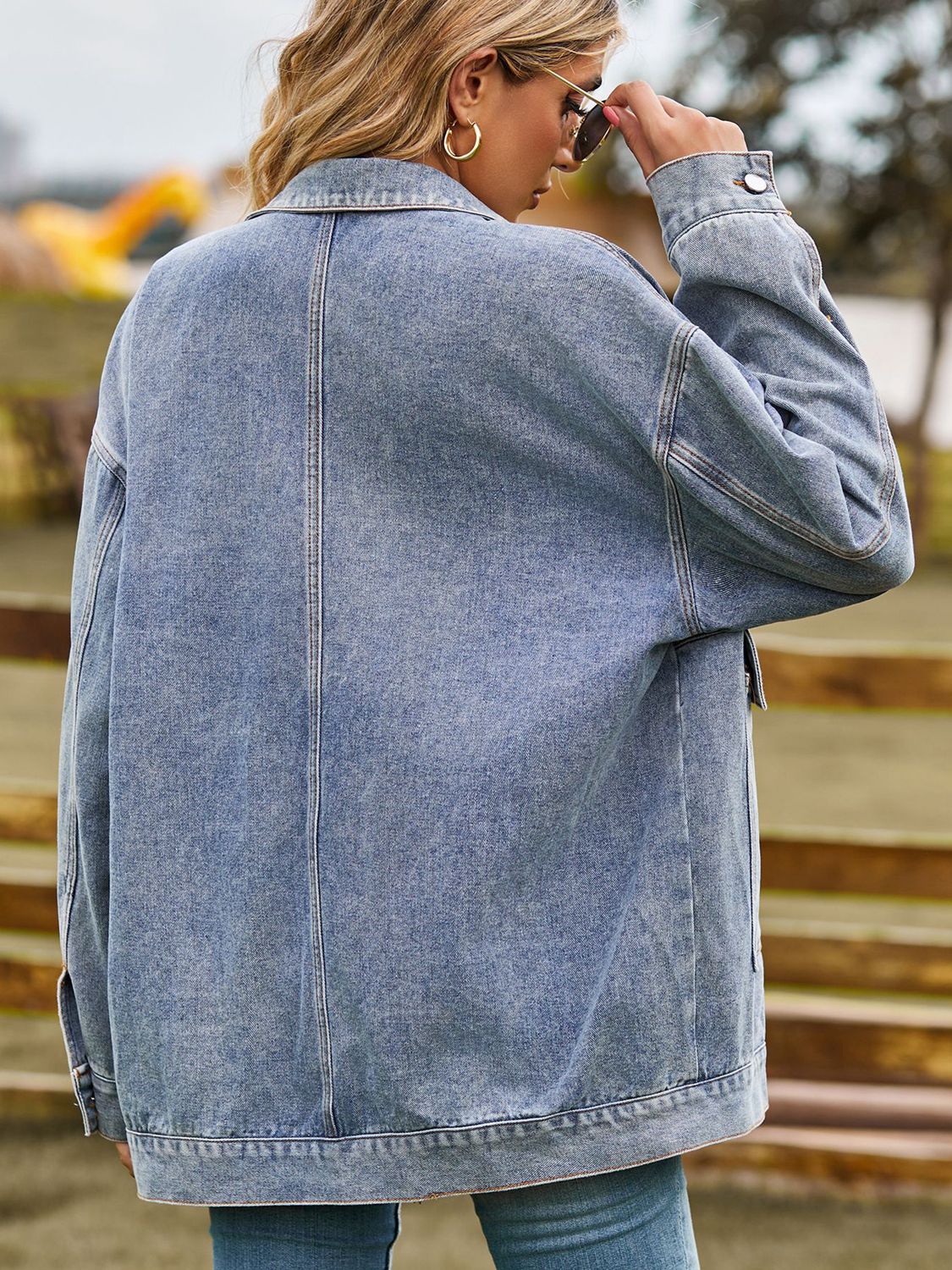 Oversized denim trucker jacket in light wash with collared neck and button cuffs.