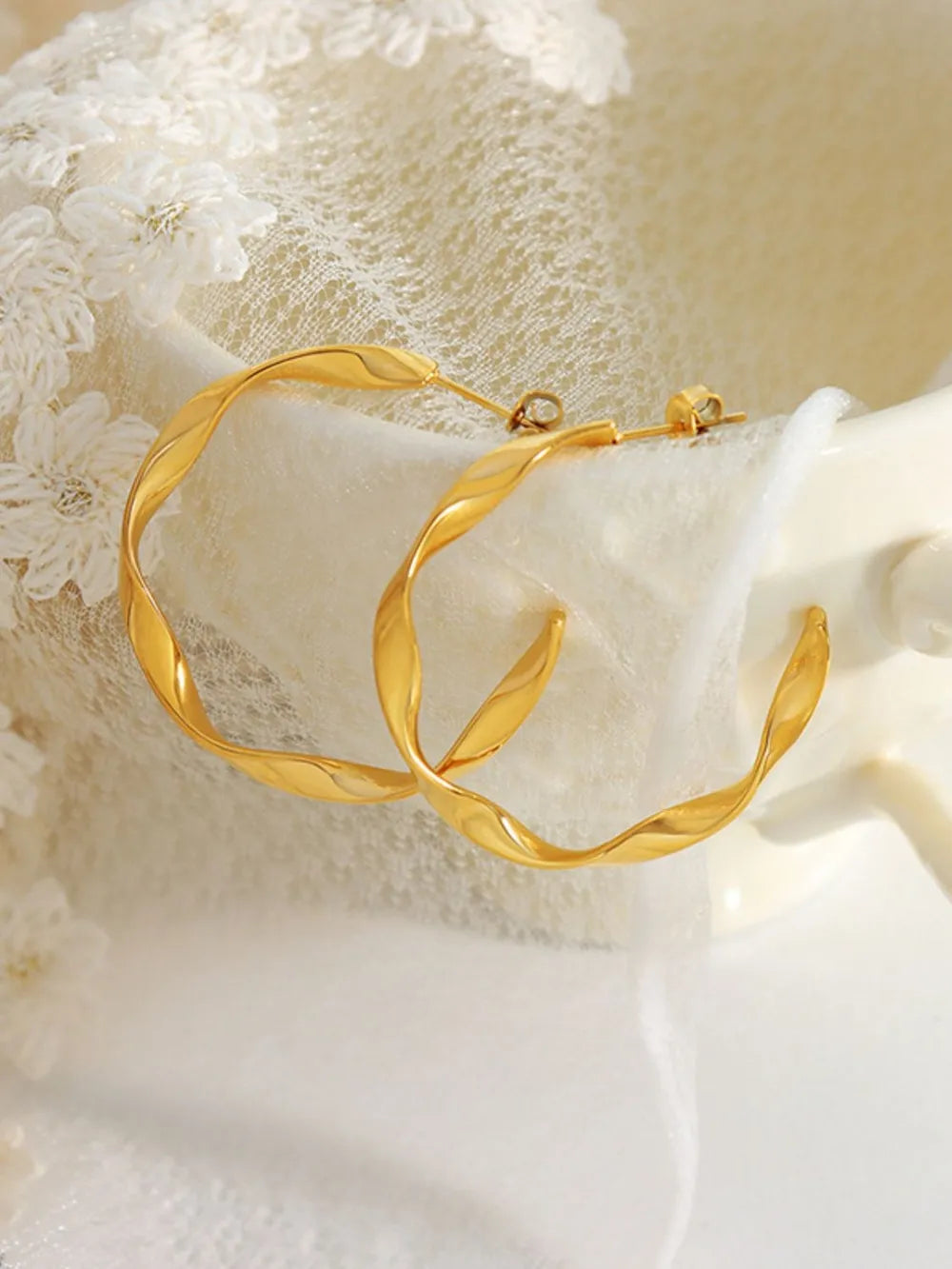 Gold twisted hoop earrings with a sculpted design.