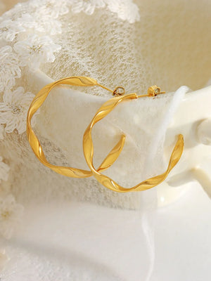 Gold twisted hoop earrings with a sculpted design.