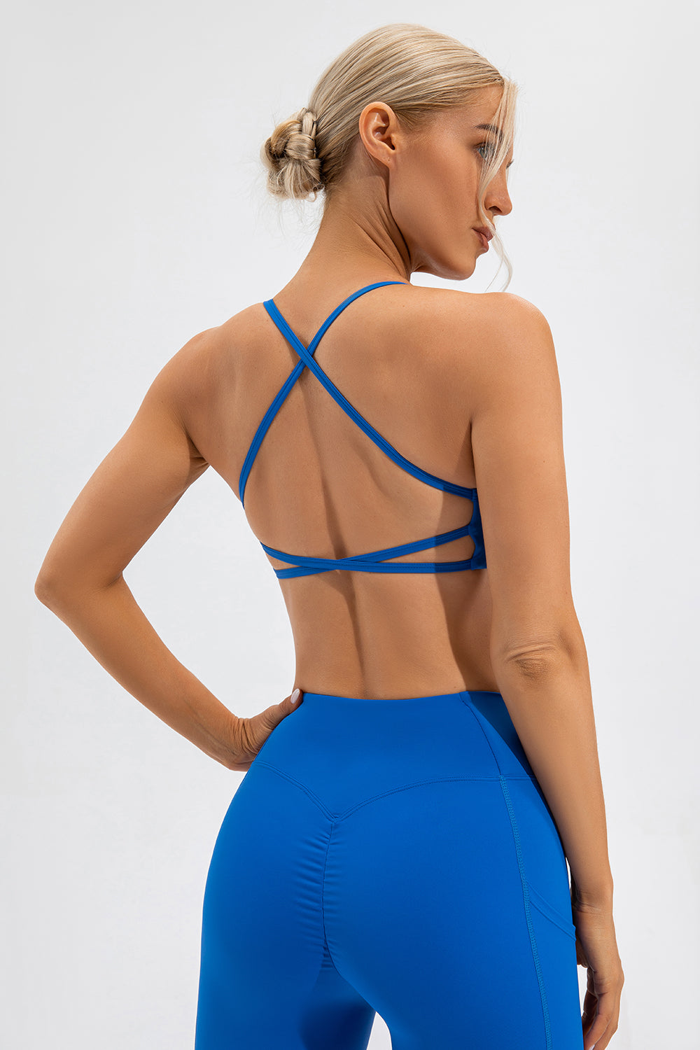 Blue sports bra with crisscross back straps and a cutout detail.