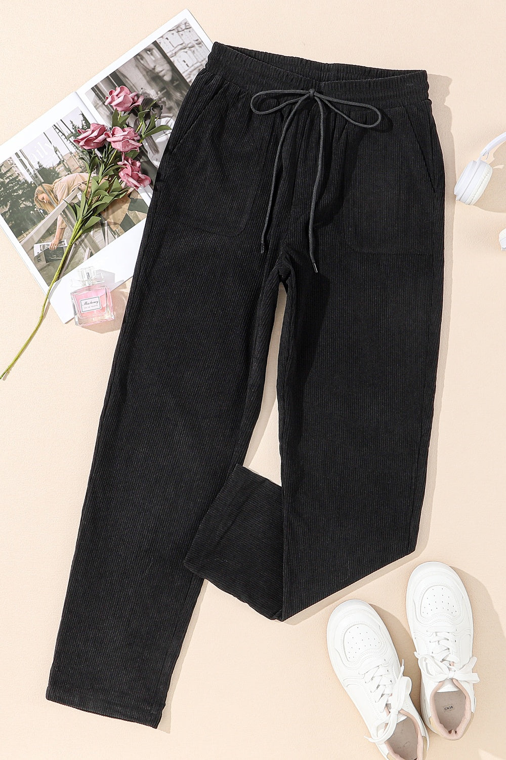 Black corduroy drawstring trousers with slant pockets and a relaxed fit.