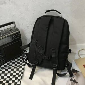 Black utility buckle backpack with adjustable straps and zipper details.
