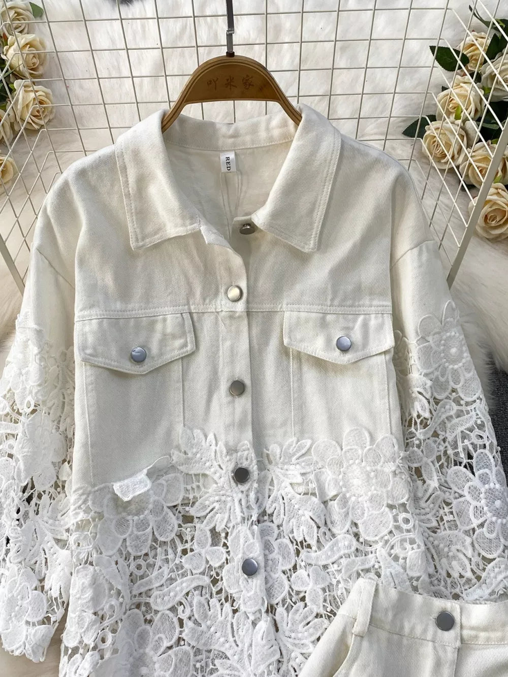 White two-piece set with lace embellishments on sleeves and hem, collared button-up jacket.
