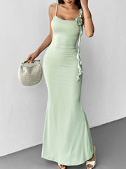 Mint green ruffled mermaid maxi dress with spaghetti straps and floral detail.