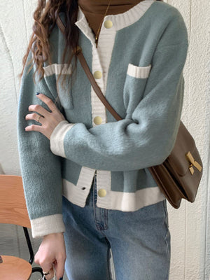 Blue acrylic cardigan with contrast trim, button up front, and gold buttons.