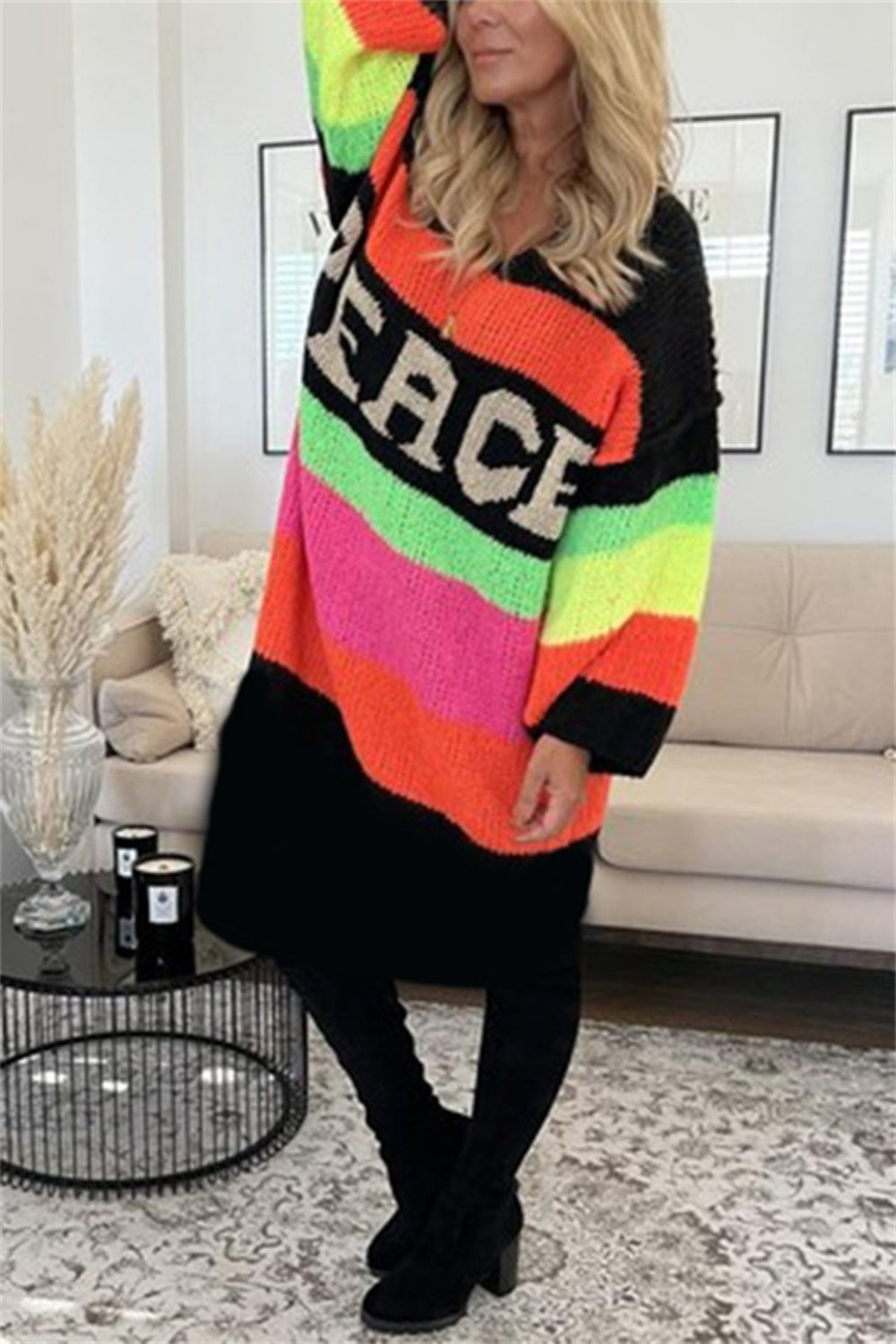 Rainbow stripe knit midi sweater dress with PEACE lettering, v-neck, long sleeves, and black bottom.