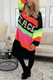 Rainbow stripe knit midi sweater dress with PEACE lettering, v-neck, long sleeves, and black bottom.