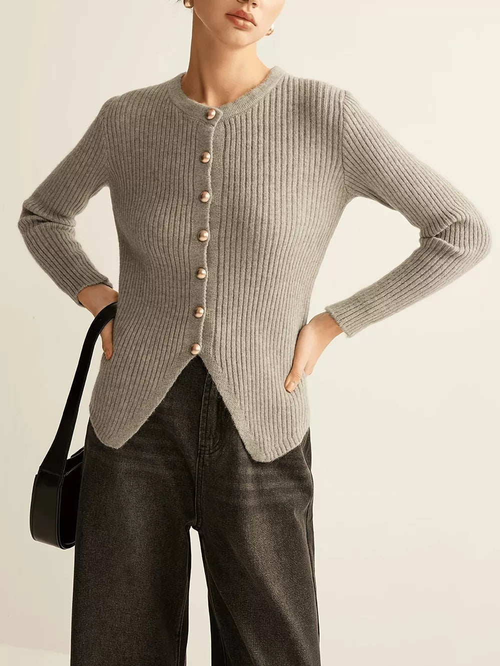 Grey ribbed knit cardigan with crew neck, gold buttons, and asymmetrical hem.