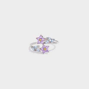 Silver ring with purple floral bypass design and blue leaf accents.
