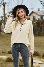 Ivory textured knit polo shirt with button placket and long sleeves.