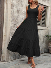 Black smocked bodice tiered maxi dress with square neckline and sleeveless design.