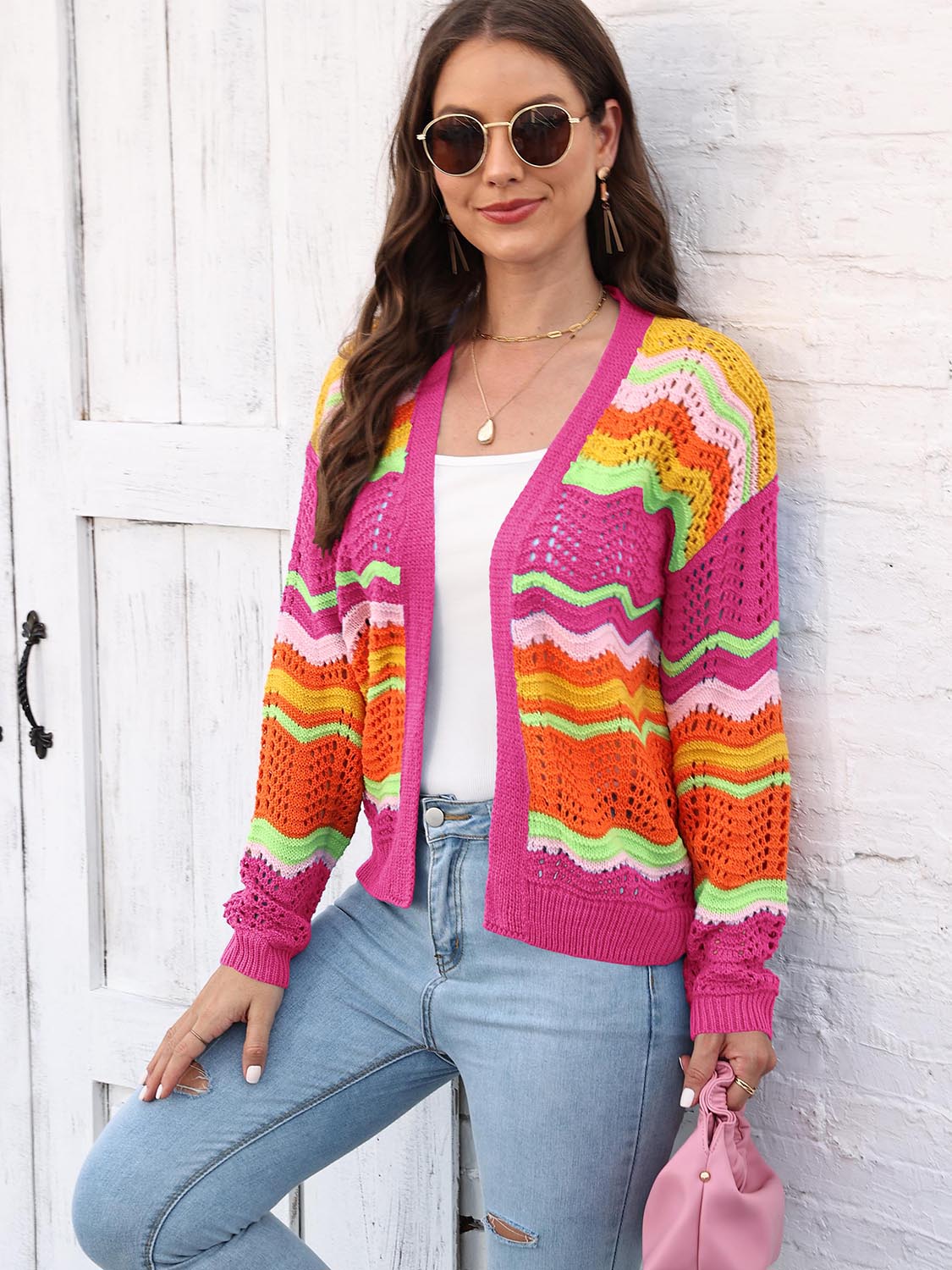 Rainbow wave crochet cardigan with open front and colorful chevron stripes.