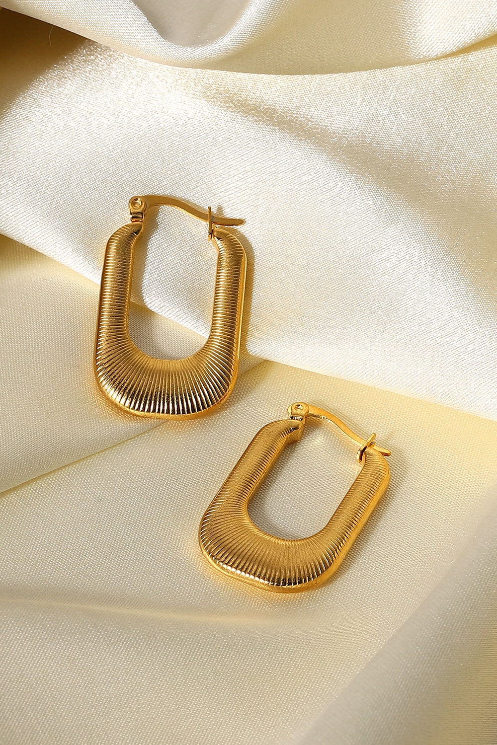 Gold textured rectangular hoop earrings with a ribbed design.