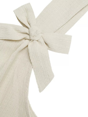 Cream textured romper with bowknot strap detail