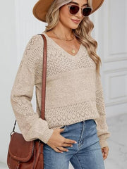 Tan eyelet stitch V-neck pullover sweater with textured panels and long sleeves.