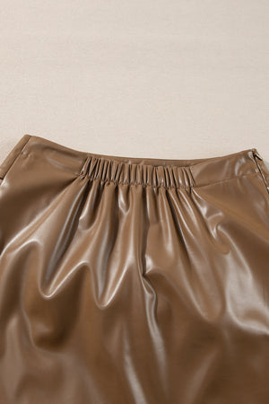 Brown faux leather mini skirt with ruched elastic waistband and knot detail.