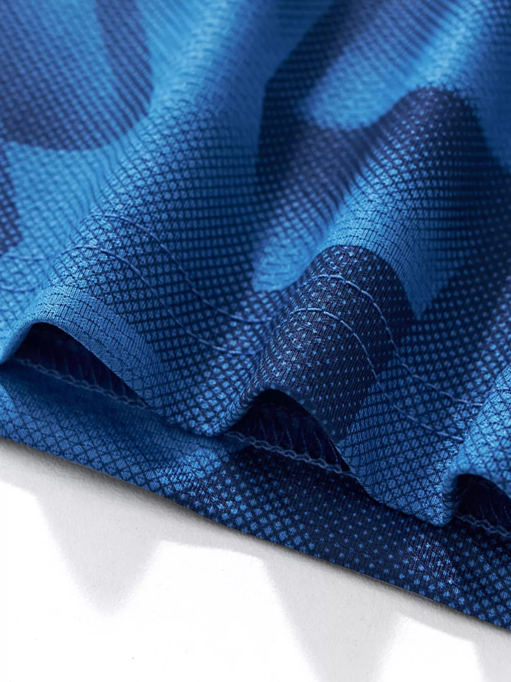 Boys' dark blue geometric print activewear set detail with breathable fabric texture.
