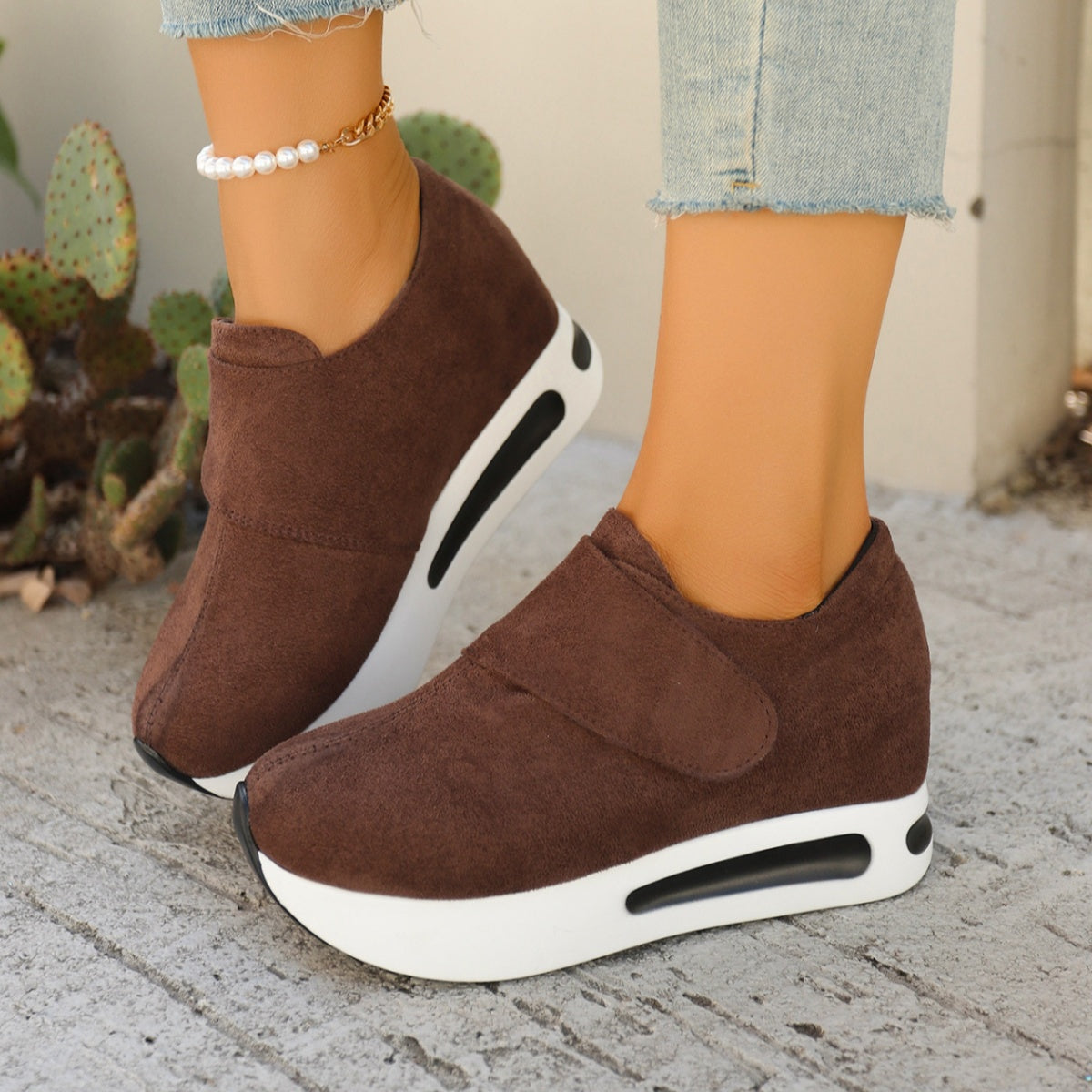 Brown chunky platform sneakers with air cushion sole and hook-and-loop strap.
