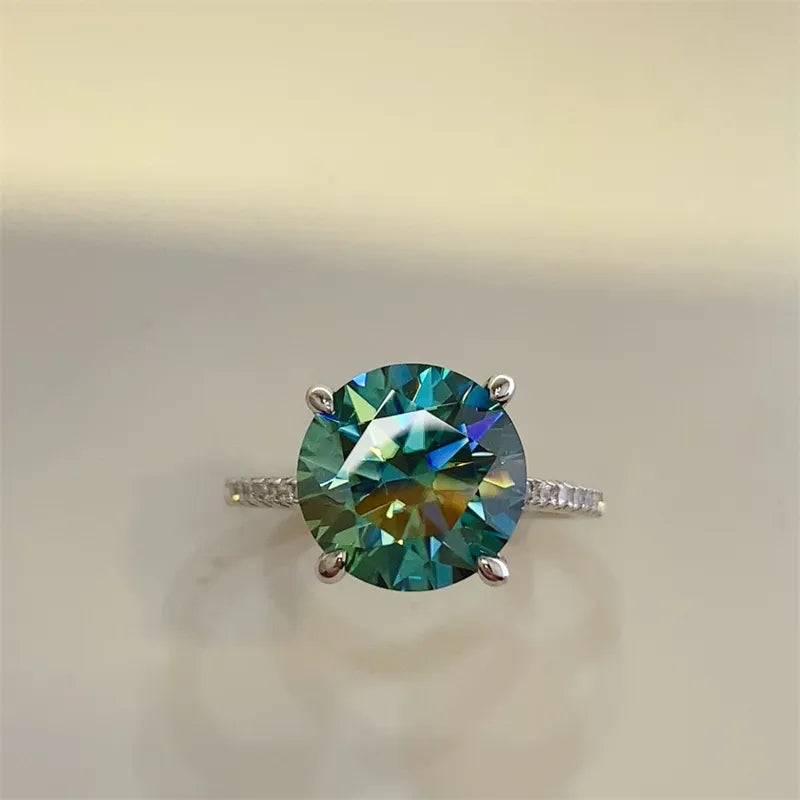 Radiant teal moissanite pavé ring in silver with a large round-cut center stone.