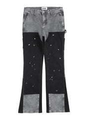 Split panel bootcut jeans in dark gray and black with paint splatter detail.