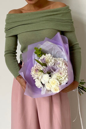 Sage ribbed knit off-the-shoulder top with long sleeves, styled casually.