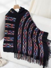 Black hooded knit cape with colorful diamond and stripe pattern and fringe detail