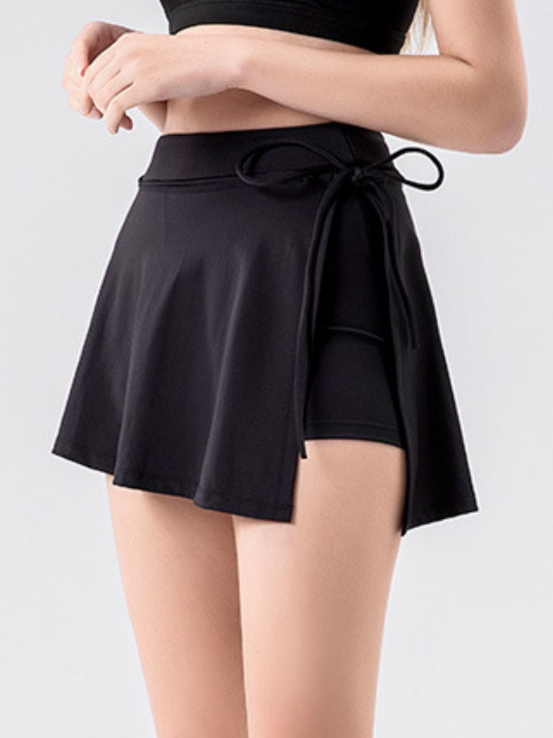 Black wrap-detail skort with side tie and built-in shorts.