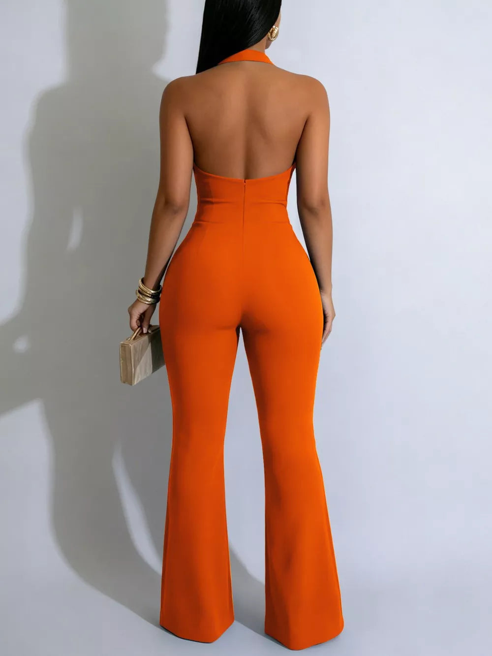 Orange halter cut-out jumpsuit with buttons and flared legs.