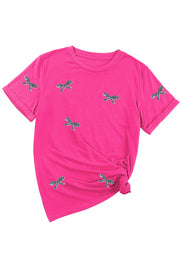 Hot pink t-shirt with embroidered bows and rolled sleeves, tied at the side.