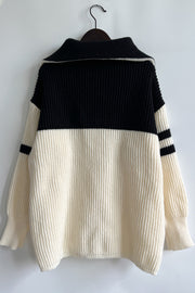 Ribbed knit quarter-zip sweater in cream and black with stripe detail on sleeves.