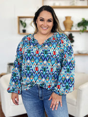 Prismatic ikat blouse with voluminous sleeves and V-neck in blue and green.