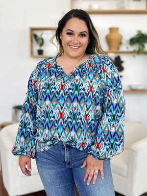 Prismatic ikat blouse with voluminous sleeves and V-neck in blue and green.