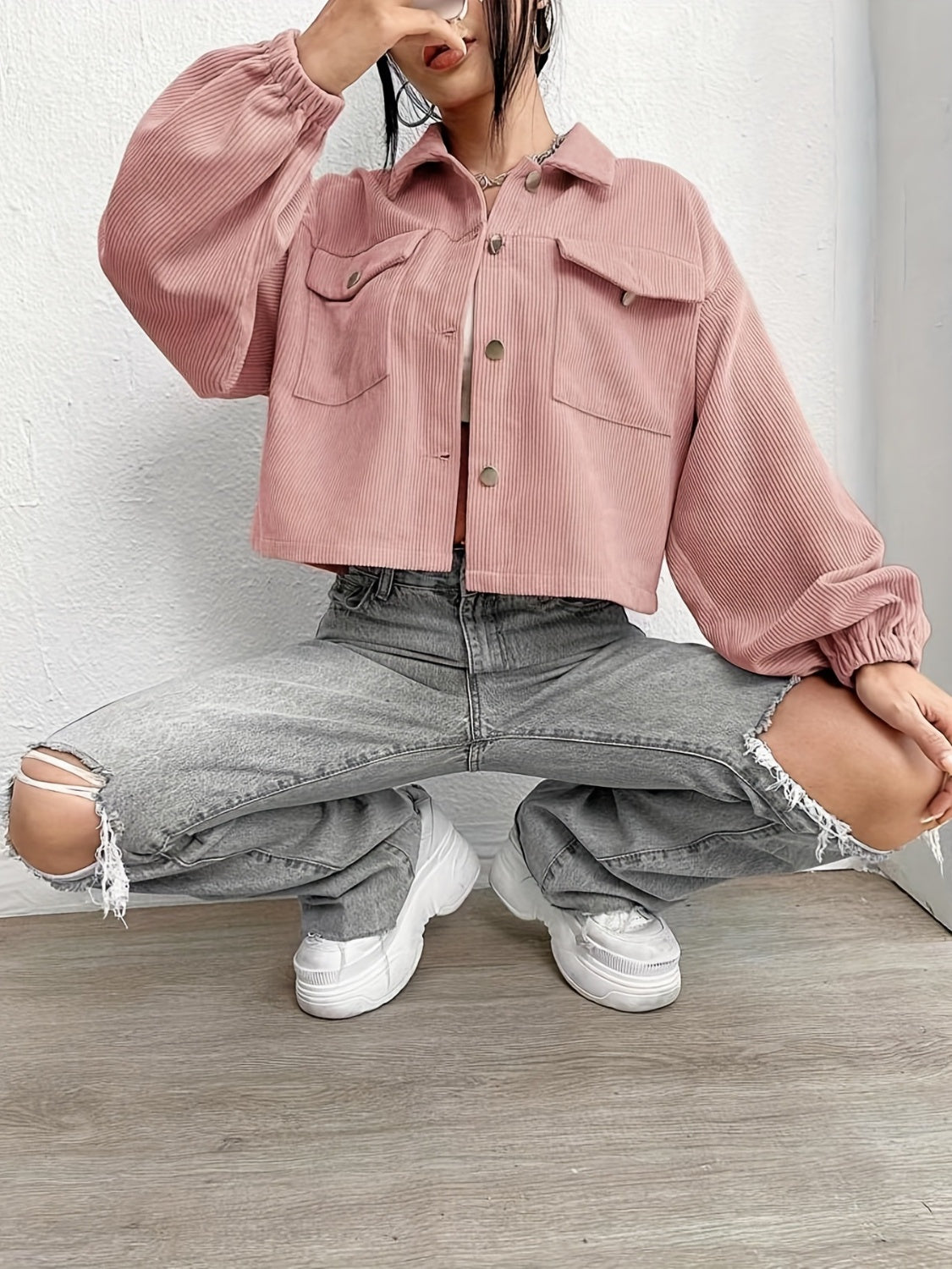 Pale blush corduroy blouson jacket with balloon sleeves and button front, styled with ripped jeans.
