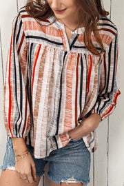 Vertical stripe gathered yoke blouse with V-neck and long sleeves.