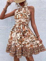 Floral print halter neck tie-waist mini dress with ruffled hem in tan.