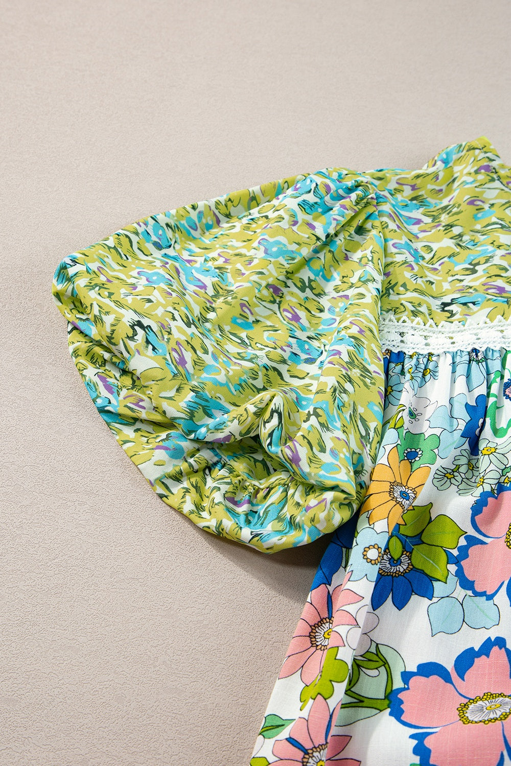 Floral patchwork blouse with puff sleeves and crochet trim, featuring lime and multi-color floral prints.
