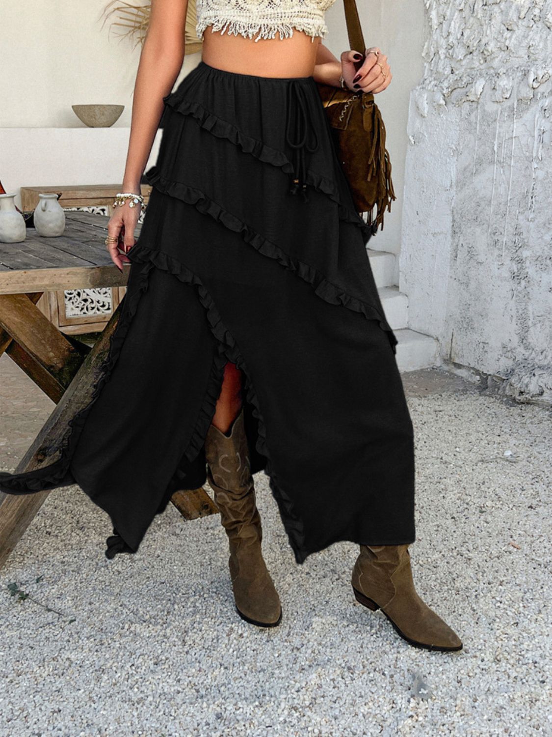 Black midi skirt with cascading ruffles and a thigh-high slit.
