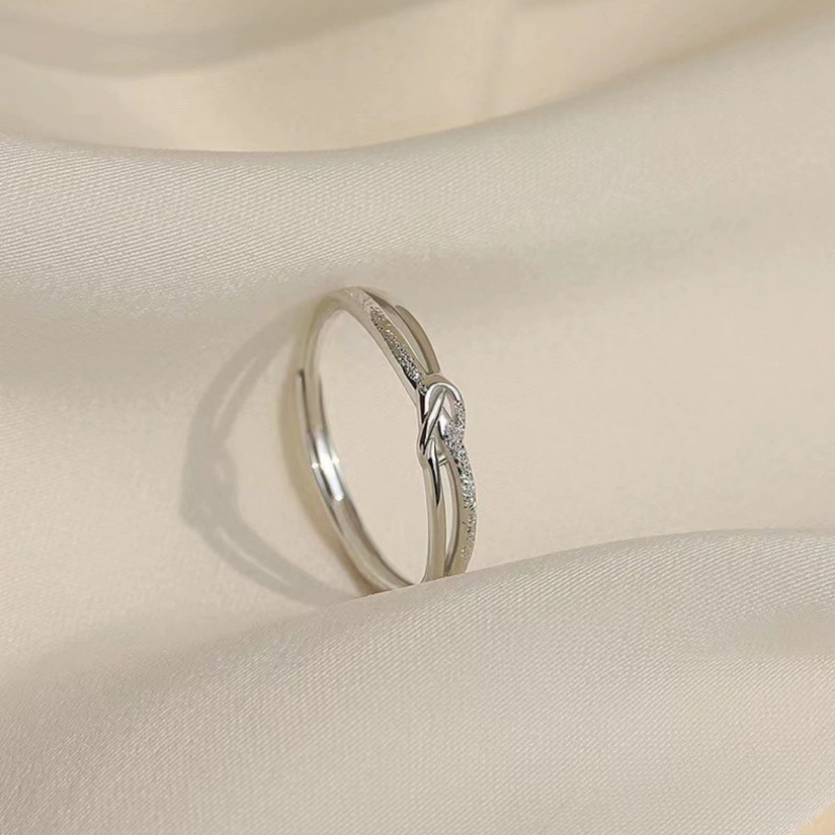 Silver knot ring with subtle sparkle detail on adjustable band