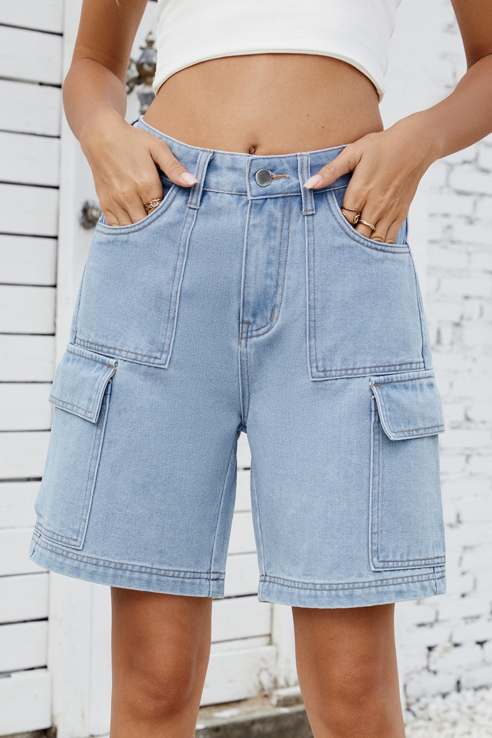 Medium wash denim utility shorts with large cargo pockets and contrast stitching.