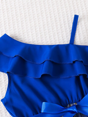 Royal blue asymmetrical toddler dress with tiered ruffles and a satin bow detail.